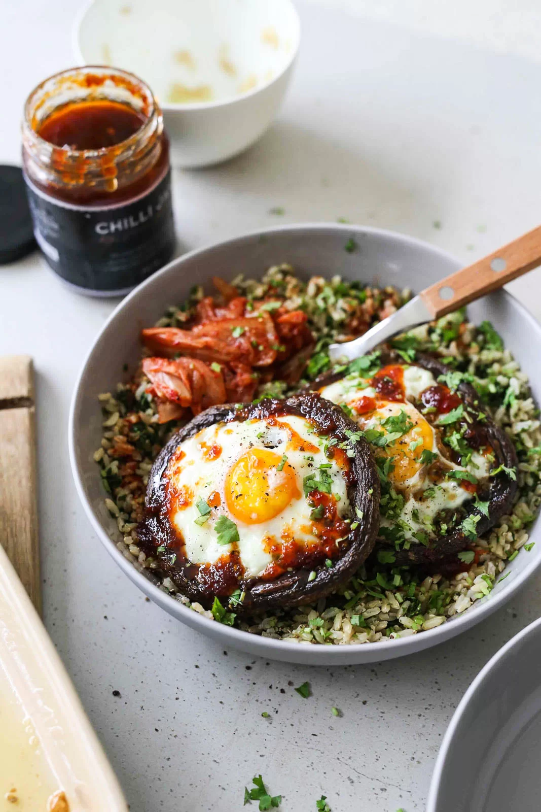 Baked eggs in mushrooms with spinach rice and kimchi
